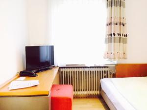 Schlafzimmer mit einem Schreibtisch, einem Computer und einem Bett in der Unterkunft Hotel Imperial in Wuppertal