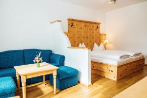 a room with a couch and a bed and a table at Appartments Bergland an der Brunnachbahn in Bad Kleinkirchheim