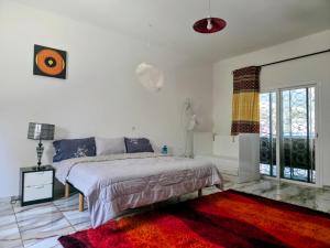 a bedroom with a bed and a red rug at Villa Ross in Saly Portudal