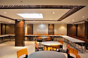 a restaurant with tables and chairs in a room at Hotel Radiant in Kolkata