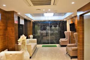 a lobby with couches and chairs in a building at Hotel Radiant in Kolkata