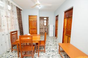 a dining room with a wooden table and chairs at Kigwedeni Apartments in Kinyasini