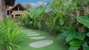 a garden with a stepping stone path in the grass at Villa Uma Sawan By 25Hours Hospitality in Bedahulu +12 photos
