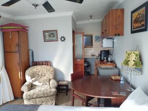 a living room with a table and a chair at Rosa Villa in Hermanus +16 photos