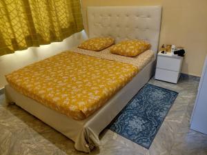 ein Bett mit zwei Kissen darauf in einem Schlafzimmer in der Unterkunft Residence Mobagnes in Kinshasa
