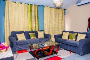 ein Wohnzimmer mit zwei blauen Sofas und einem Tisch in der Unterkunft Residence Mobagnes in Kinshasa