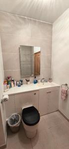a bathroom with a toilet and a sink with a mirror at Boyne Place in East Hoathly