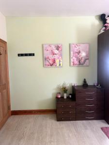 a living room with a dresser and three pictures on the wall at Boyne Place in East Hoathly