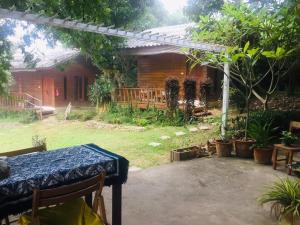 a house with a table in a yard with plants at Pai yard on Hill in Pai