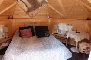 1 dormitorio con 1 cama en una cabaña de madera en Abrikota, en Saint-Christophe-du-Jambet