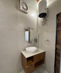 a bathroom with a white sink and a mirror at CNS Hotels in Ghaziabad