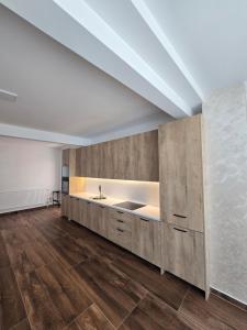 a kitchen with a sink in a room with wooden floors at Hotel Arbëri Events in Rahovec