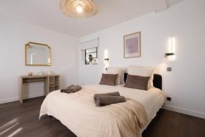 a bedroom with a large bed with white walls at Spacious Designer Duplex 9 Guests Fully Renovated in Châtillon