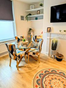 a living room with a glass table and chairs at Stylish Townhouse - 8 Mins From Leeds - Free Fast WiFi - Free Parking in Headingley