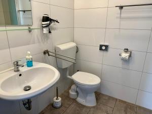 a bathroom with a white toilet and a sink at Die Schlafstube - Apartments und mehr in Neuharlingersiel +34 photos