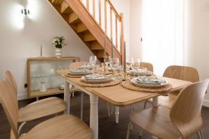 a dining room with a wooden table with wine glasses at Spacious Designer Duplex 9 Guests Fully Renovated in Châtillon