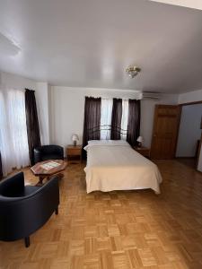 a bedroom with a bed and a chair and a table at ERV Club - Villas in Lixouri