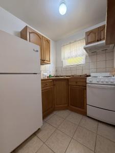 a kitchen with a white refrigerator and wooden cabinets at ERV Club - Villas in Lixouri