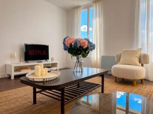 a living room with a table and a vase of flowers at Spacious Designer Duplex 9 Guests Fully Renovated in Châtillon