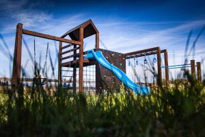 a playground with a blue slide in the grass at Brdy Koniakowskie in Koniaków