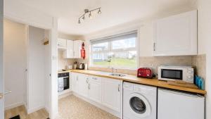 a kitchen with a sink and a microwave at F59 Trevone, Riviere Towans in Hayle