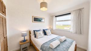 a bedroom with a bed and a window at F59 Trevone, Riviere Towans in Hayle +4 photos