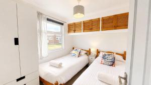 two beds in a small room with a window at F59 Trevone, Riviere Towans in Hayle