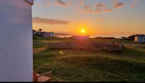 a sunset over the ocean with the sun in the sky at F59 Trevone, Riviere Towans in Hayle