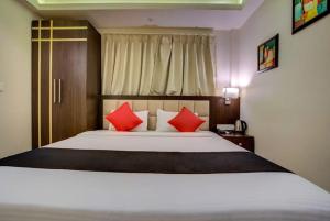a bedroom with a large bed with red pillows at Hotel Radiant in Kolkata