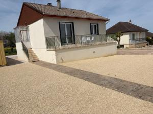 a white house with a balcony and a driveway at Maison Mara in Montliot-et-Courcelles