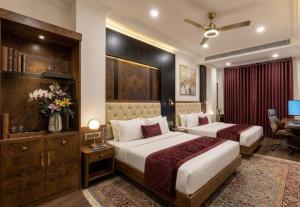 a hotel room with two beds and a desk at Hotel Grand Heaven in Tājganj +4 photos