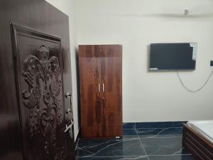a door in a room with a tv on a wall at 101 Mahalaxmi Homes in Bhubaneshwar