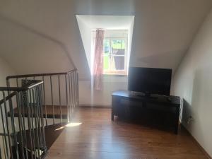 a living room with a staircase and a television on a dresser at Schwarze Gräfin in Spital am Pyhrn