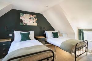 two beds in a room with green walls at Riverside Cottage in Cairngorms in Ballater +19 photos