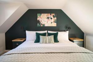 a bedroom with a large bed with green walls at Riverside Cottage in Cairngorms in Ballater