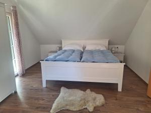 a bedroom with a bed with blue sheets and a rug at Schwarze Gräfin in Spital am Pyhrn
