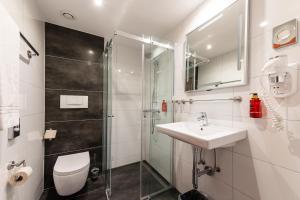 a bathroom with a toilet and a sink and a shower at City Hotel Heilbronn in Heilbronn