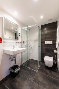 a bathroom with a sink and a shower and a toilet at City Hotel Heilbronn in Heilbronn