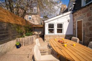 a wooden table and chairs on a patio at Riverside Cottage in Cairngorms in Ballater
