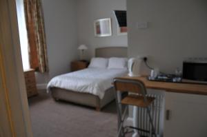 a bedroom with a bed and a desk with a chair at Westham in Warwick