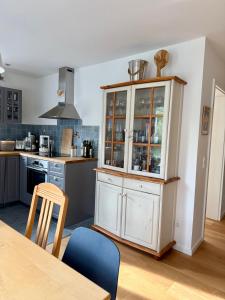 a kitchen with a large white cabinet with glass doors at Ferienwohnung LANDZEIT in Bad Soden-Salmünster