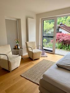 a bedroom with a bed and two chairs and a window at Ferienwohnung LANDZEIT in Bad Soden-Salmünster