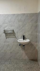 a white sink on a wall in a bathroom at 3Z Homestay in Bayan