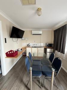 a room with a table and chairs and a kitchen at Tamworth Lodge Motel in Tamworth