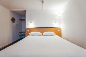 a bedroom with a large white bed with two pillows at The Beacon Hotel, Cardiff, Part of the AG Collection in Cardiff