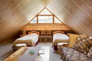 a room with two beds and a couch in a attic at Tabina puhkemaja in Tabina