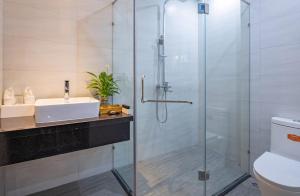 a bathroom with a glass shower and a sink at Seasol Beach Boutique hotel in Danang +16 photos