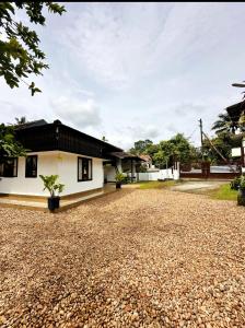 a house with a gravel driveway at Cherys Bunglow Homestay- Rooms in Thiruvalla