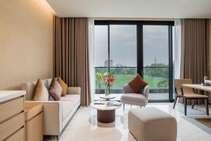 a living room with a couch and a table at The Five Hotel & Resort Evara - 24 Hours stay in Dong Anh