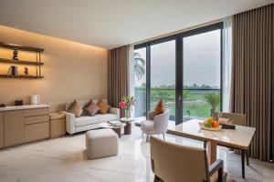 a living room with a couch and a table at The Five Hotel & Resort Evara - 24 Hours stay in Dong Anh